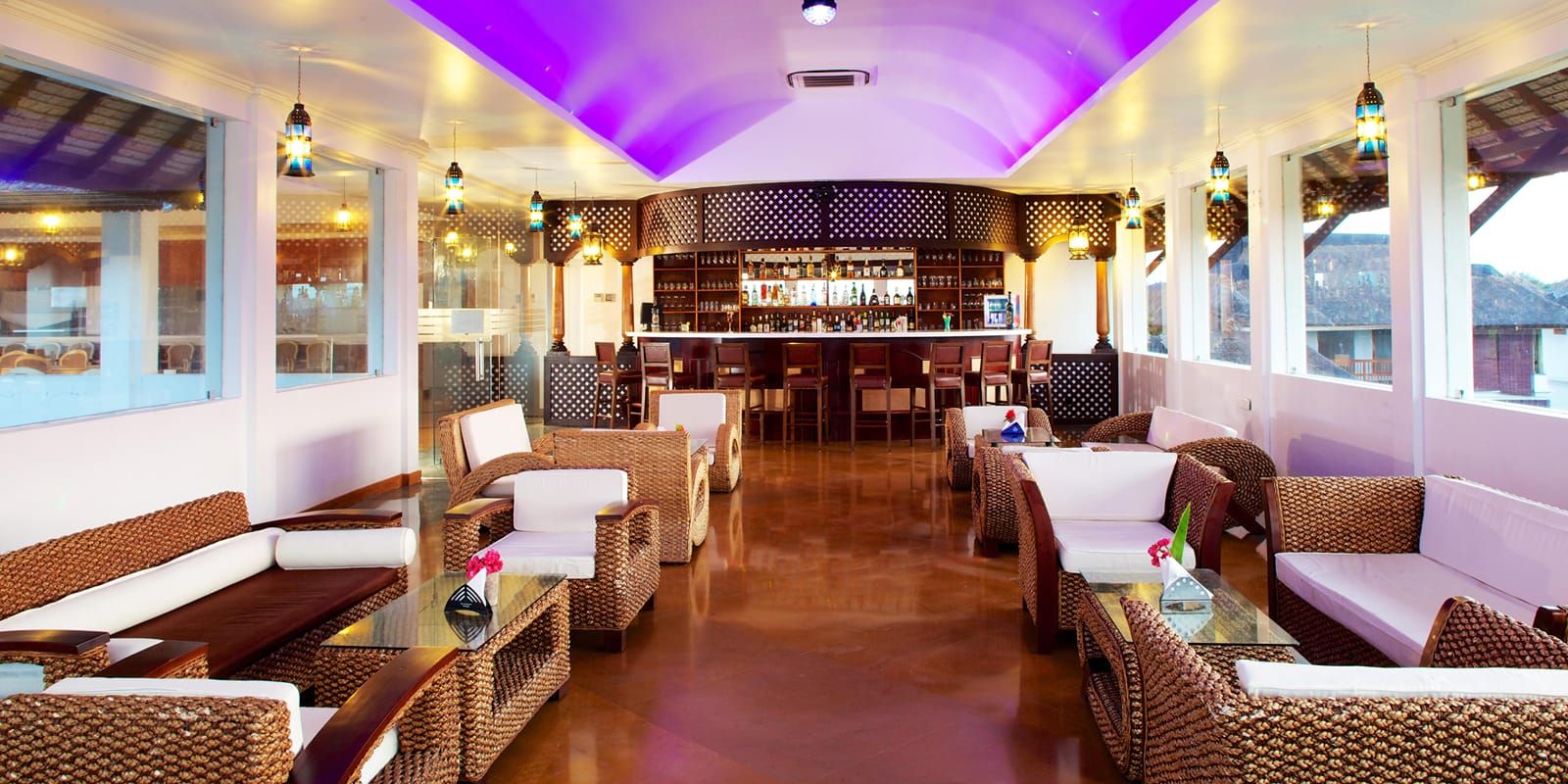 Indoor Bar lounge with wicker sofas, white cushions and a curved bar counter