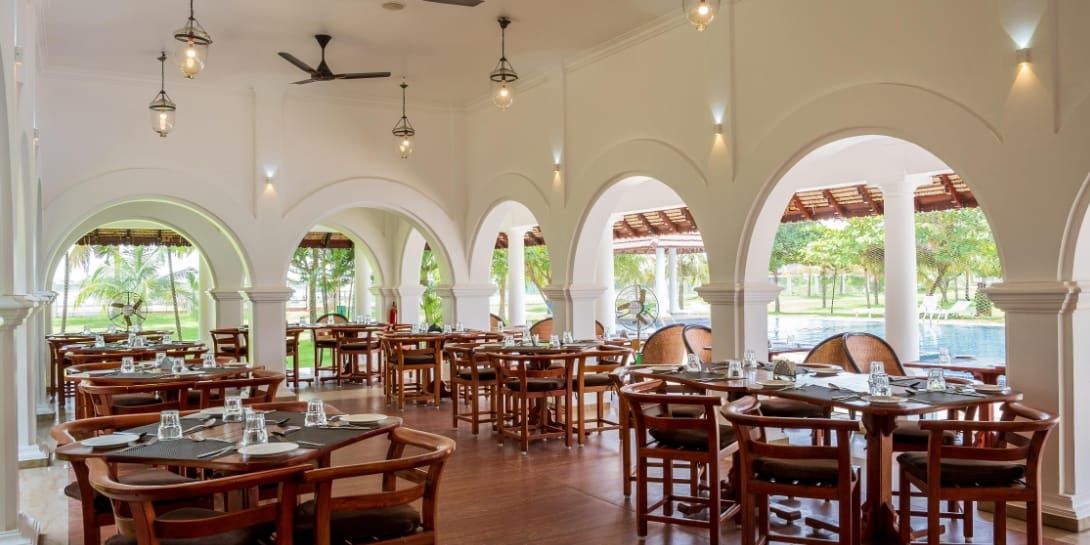 Smaak dining room with wooden tables and white arched columns